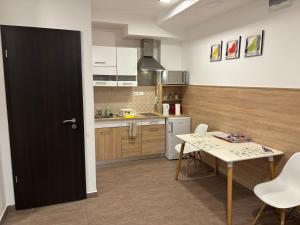 kuchnia ze stołem i czarnymi drzwiami w obiekcie Pizza Tábor Apartman w Miszkolcu