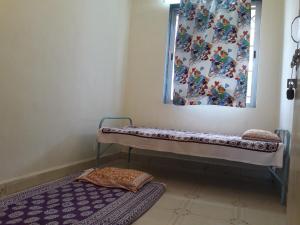 内拉尔Neral Farm House Stay的窗户和地毯的房间里长凳