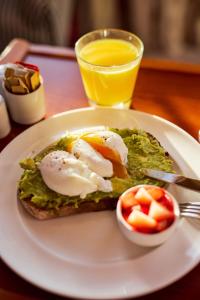a plate of food with eggs and fruit on a table at Drakes Hotel in Brighton & Hove