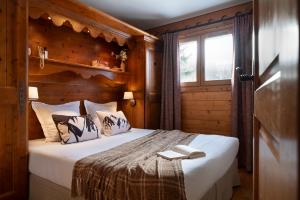een slaapkamer met een groot bed met een raam bij Résidence Pierre & Vacances Premium Les Fermes De Méribel in Méribel +61 foto's