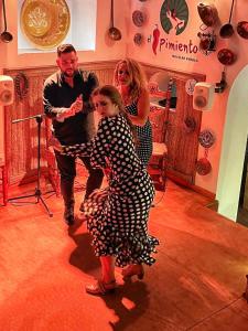 un grupo de personas de pie alrededor de una mujer con un vestido de lunares en Penthouse apartment - Mojacar Pueblo - 1 Bedroom - Sleeps 2 - R105, en Mojácar