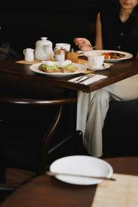 a woman sitting at a table with plates of food at Drakes Hotel in Brighton & Hove