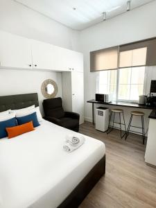 a bedroom with a large bed and a kitchen at Stylish City Centre Studio - Grand Central House in Gibraltar
