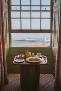 a table with a plate of food and a window at Drakes Hotel in Brighton & Hove