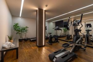 a gym with treadmills and exercise bikes in a room at MONDI Hotel Axams in Innsbruck