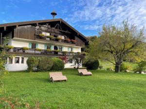 a building with two benches in the grass at Ferienwohnung Berglodge Chiemsee in Aschau im Chiemgau