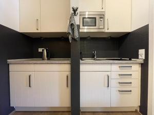 アシャウ・イム・キームガウにあるFerienwohnung Berglodge Chiemseeの白いキャビネットと電子レンジを備えたキッチン