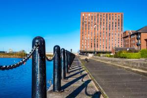 una cadena en una cerca junto a un cuerpo de agua en Fabulous Quayside Apartment with Free Parking, en Liverpool