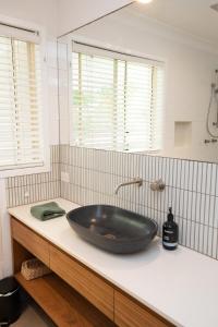 La salle de bains est pourvue d'un grand lavabo noir sur un comptoir. dans l'établissement Harper House, à Suffolk Park 14 autres photos