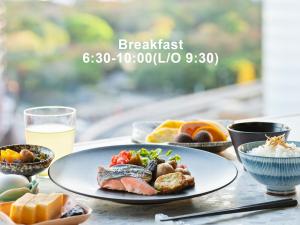 東京にあるMitsui Garden Hotel Ginza Premierの食べ物の皿とオレンジジュースのグラスが置かれたテーブル