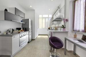 a kitchen with a purple chair in a room at Rose Sorrento House in Sorrento +8 photos