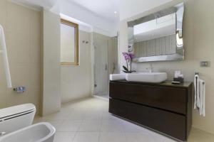 a bathroom with a sink and a toilet and a mirror at Rose Sorrento House in Sorrento