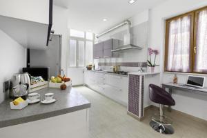 a kitchen with white cabinets and a purple chair in it at Rose Sorrento House in Sorrento