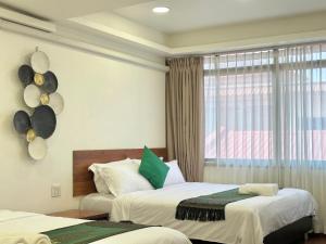a hotel room with two beds and a window at Longzhu Guesthouse in Bangkok