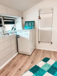 a kitchen with a dishwasher and a beach sign on it at FeWo Ostseeglück in Biendorf