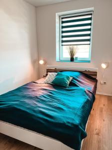 a bedroom with a large bed with a window at FeWo Ostseeglück in Biendorf +6 photos