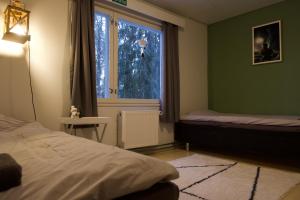 een slaapkamer met een bed en een raam bij Taigaschool Eco Hotel in Virrankylä