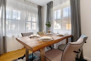 a dining room with a wooden table and chairs at Ferienwohnung Merlin in Ettenheim +16 photos