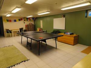 a ping pong table in a room with a table at Taigaschool Eco Hotel in Virrankylä
