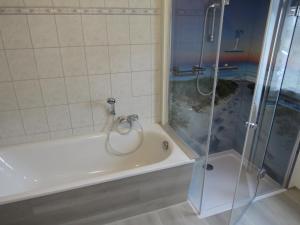 a bathroom with a shower and a white bath tub at FeWo Bergstadt Ehrenfriedersdorf in Ehrenfriedersdorf