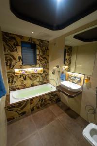 a bathroom with a bath tub and a sink at Royal Cabana Lonavla - 6BHK Luxury Villa with Heated pool and Turf in Lonavala