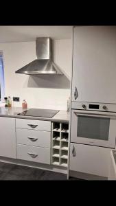 Una cocina con gabinetes blancos y un horno de estufa. en 2 Bed-Sleeps 4-Parking-Beachside-Golf Access, en Southport