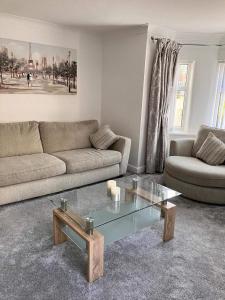 sala de estar con sofá y mesa de centro de cristal en 2 Bed-Sleeps 4-Parking-Beachside-Golf Access, en Southport