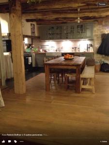 una cocina con una mesa de madera y un bol de fruta. en Gîte La Grange, en Massat