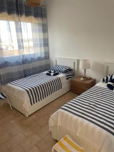 een slaapkamer met twee bedden en een raam bij Casa Mare Salento - a due passi dal mare in Marina di Lizzano