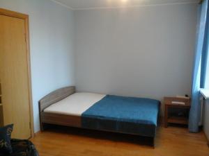 a small bedroom with a bed with a blue blanket at Apartaments LiS 2 in Petergof