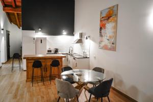 a kitchen with a table and chairs and a table and a counter at Casas Rurales LA HUERTA DEL CURATO I in Tolbaños