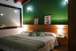 a green bedroom with a bed and a green wall at Casas Rurales LA HUERTA DEL CURATO I in Tolbaños +17 photos
