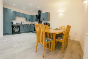 a kitchen with a wooden table and chairs at Hidden Gem in Plymouth +8 photos