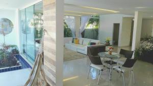 a living room with a table and a couch at Belíssima Casa Condominio e Mar in Paripueira