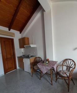 a kitchen with a table and two chairs and a table at Marina Studios I in Argostoli