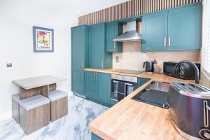 a kitchen with green cabinets and a counter top at The Townhouse Ballycastle in Ballycastle