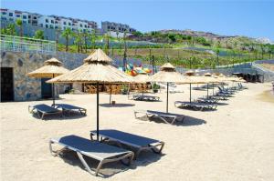 a group of beach chairs and umbrellas on a beach at 2 Bedroom Castamar Residence in Bogazici