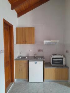 a kitchen with a white refrigerator and a microwave at Marina Studios I in Argostoli +50 photos