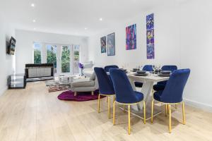 a dining room with a table and blue chairs at Purple Reignz - 3BR - close to LDN in Brent Station