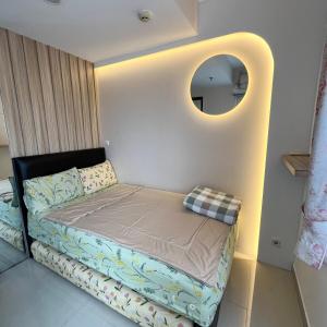a small bed in a room with a mirror at Minimalist 2BR @Sudirman Suites Apartment in Bandung