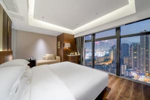 Rúm í herbergi á Chongqing Junsheng Yunduan Riverview Hotel