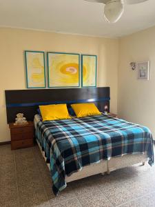 Un dormitorio con una cama con dos almohadas amarillas. en Lindo Sobrado Amarelo -próximo a praia, en Mongaguá
