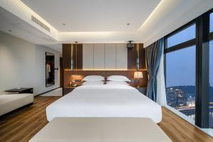 Postel nebo postele na pokoji v ubytování Chongqing Junsheng Yunduan Riverview Hotel