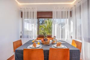 een eetkamer met een tafel met eten erop bij Sun & Beach Alvor in Alvor