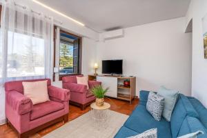een woonkamer met twee stoelen en een tv bij Sun & Beach Alvor in Alvor