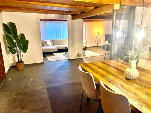 a large living room with a wooden table and chairs at Maison Verdeau Ferien am Murtensee in Faoug