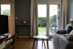 Μια τηλεόραση ή/και κέντρο ψυχαγωγίας στο Appartement avec piscine commune - quartier Pironnière - 4 personnes