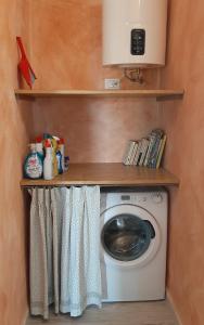 a laundry room with a washing machine and shelves at Country villa Sant' Elène- Appartamento Mirto in Orosei