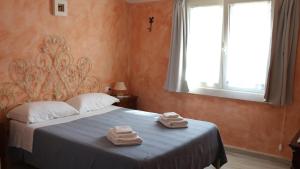 a bedroom with a bed with two towels on it at Country villa Sant' Elène- Appartamento Mirto in Orosei