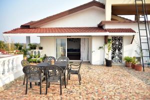 a patio with a table and chairs in front of a house at Casa Terrazzo,2bhk apartment in Sucorro-Porvorim in Pilerne